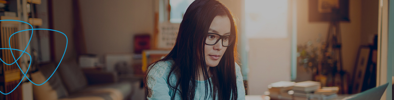 woman with long dark hair wearing glasses and a light blue sweater